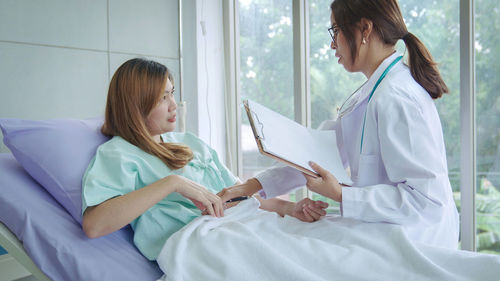 Young doctor examining patient in hospital