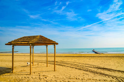 Lifeguard hut on beach against blue sky