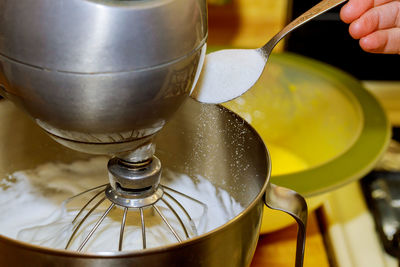 Close-up of hand pouring drink in glass