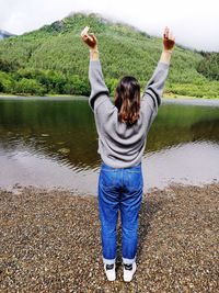 Rear view of woman standing in lake