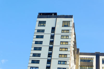 Low angle view of modern building against clear blue sky