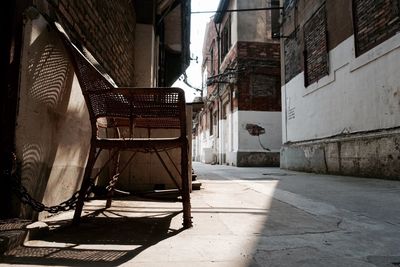 Empty chair amidst old buildings