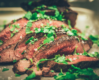 Close-up of meat garnished with cilantro on plate