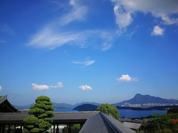 Scenic view of buildings and mountains against blue sky