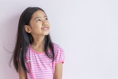 Smiling girl looking away against white background