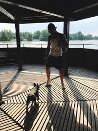 Full length of man standing by dog in gazebo