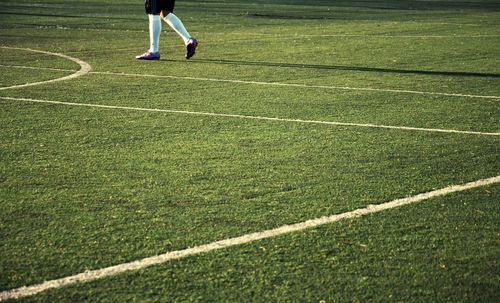 Low section of man standing on soccer field