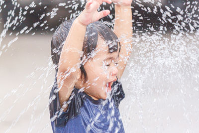 Shirtless man splashing water in pool