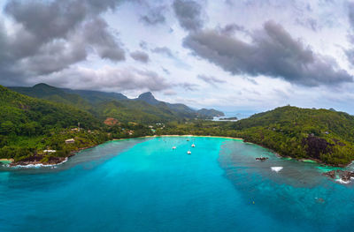 Scenic view of sea and mountains against sky