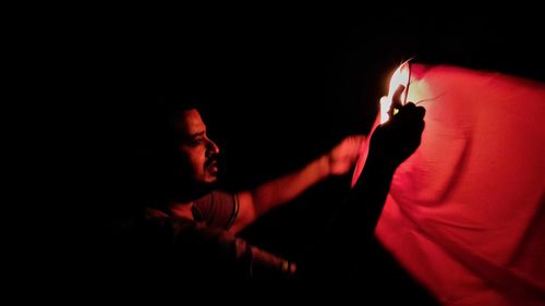 Man and red light in darkroom