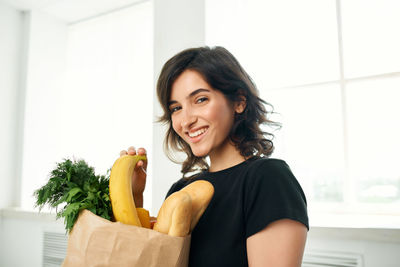 Portrait of smiling young woman against clear sky