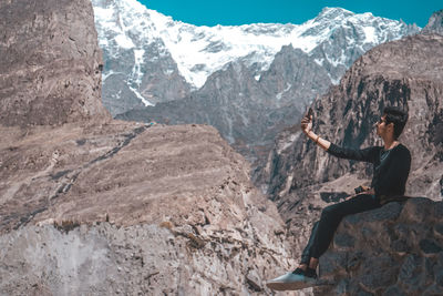 Woman standing on rock against mountains