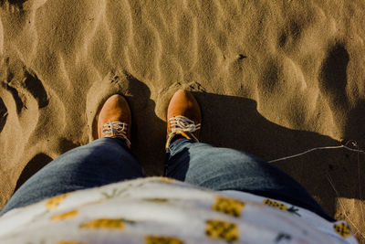 Low section of man standing on sand