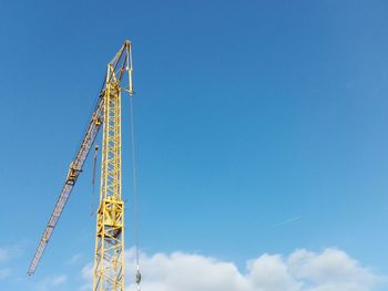 Low angle view of crane against blue sky