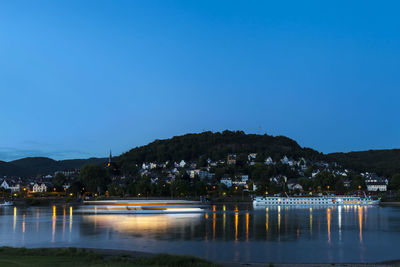 Scenic view of lake against clear blue sky at night