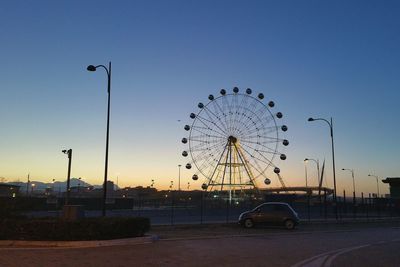 Silhouette ferris wheel against sky at sunset