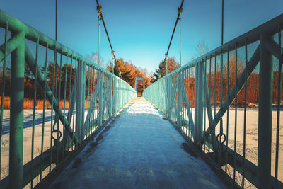 Empty footbridge against clear sky