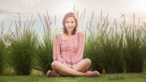 Happy young woman sitting on grass