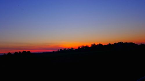 Scenic view of silhouette landscape against clear sky during sunset