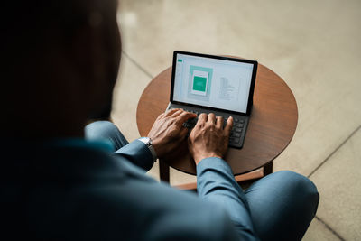 High angle view of african businessman using mobile digital tablet with keyboard 