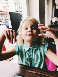 Close-up portrait of cute girl gesturing in restaurant