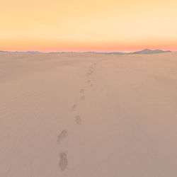 High angle view of footprints on desert at sunset