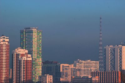 Modern buildings in city against clear blue sky