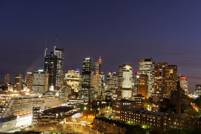 Illuminated buildings in city against sky at night