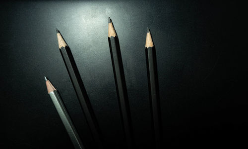 Close-up of colored pencils against black background