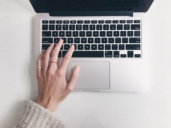 Close-up of woman using laptop keyboard