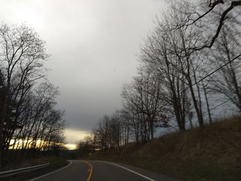 Road amidst trees against sky