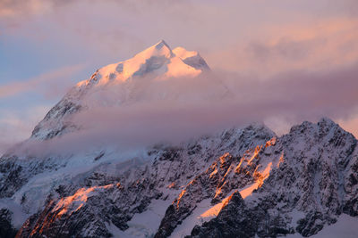 Low angle view of snow mountains against sky during sunset