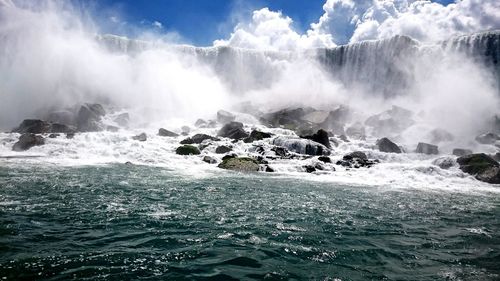 Scenic view of waterfall against sea