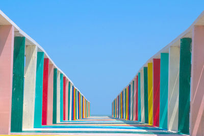 Low angle view of multi colored wooden footbridge against sky