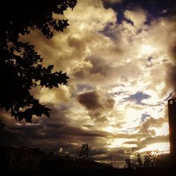 Silhouette of trees against cloudy sky