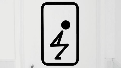 Close-up of male toilet sign over white background