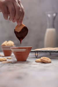 Close-up of hand holding ice cream in bowl on table