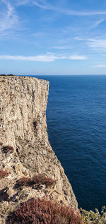 Rock formation in sea against sky