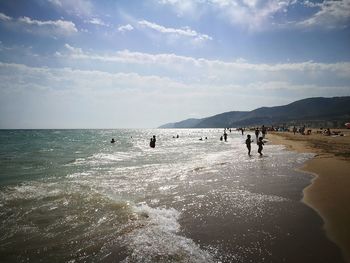 People on beach against sky