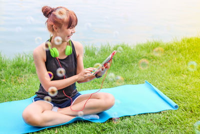 Full length of woman sitting on field