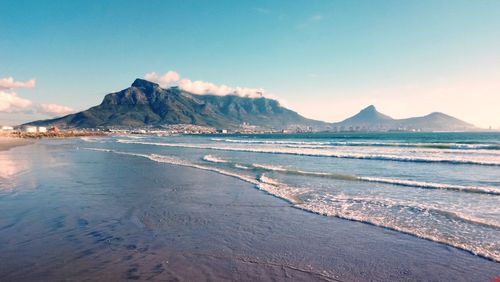 Scenic view of beach and mountains against sky