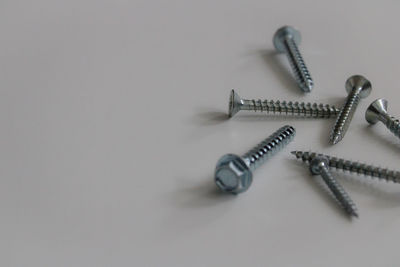 High angle view of screws on white background