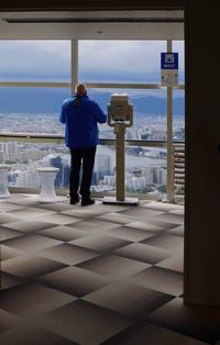 Rear view of man standing by sea