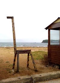 Lifeguard hut at beach against sky