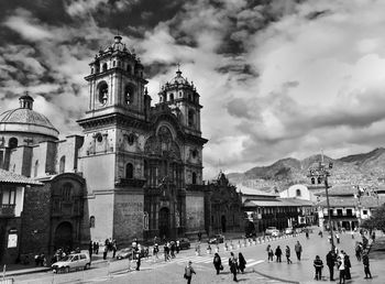 Group of people in front of church against sky