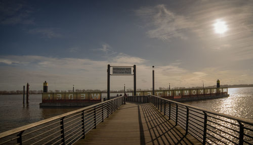 Pier over sea against sky during sunset