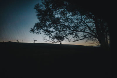 Silhouette trees on field against sky
