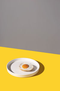 Close-up of fried egg on plate on table yellow 