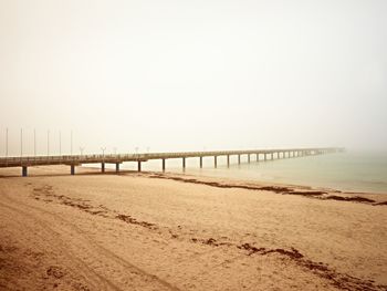 Autumn misty morning on wooden pier above sea. depression, dark atmosphere. touristic mole, wet 
