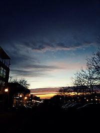 Illuminated city against sky at sunset